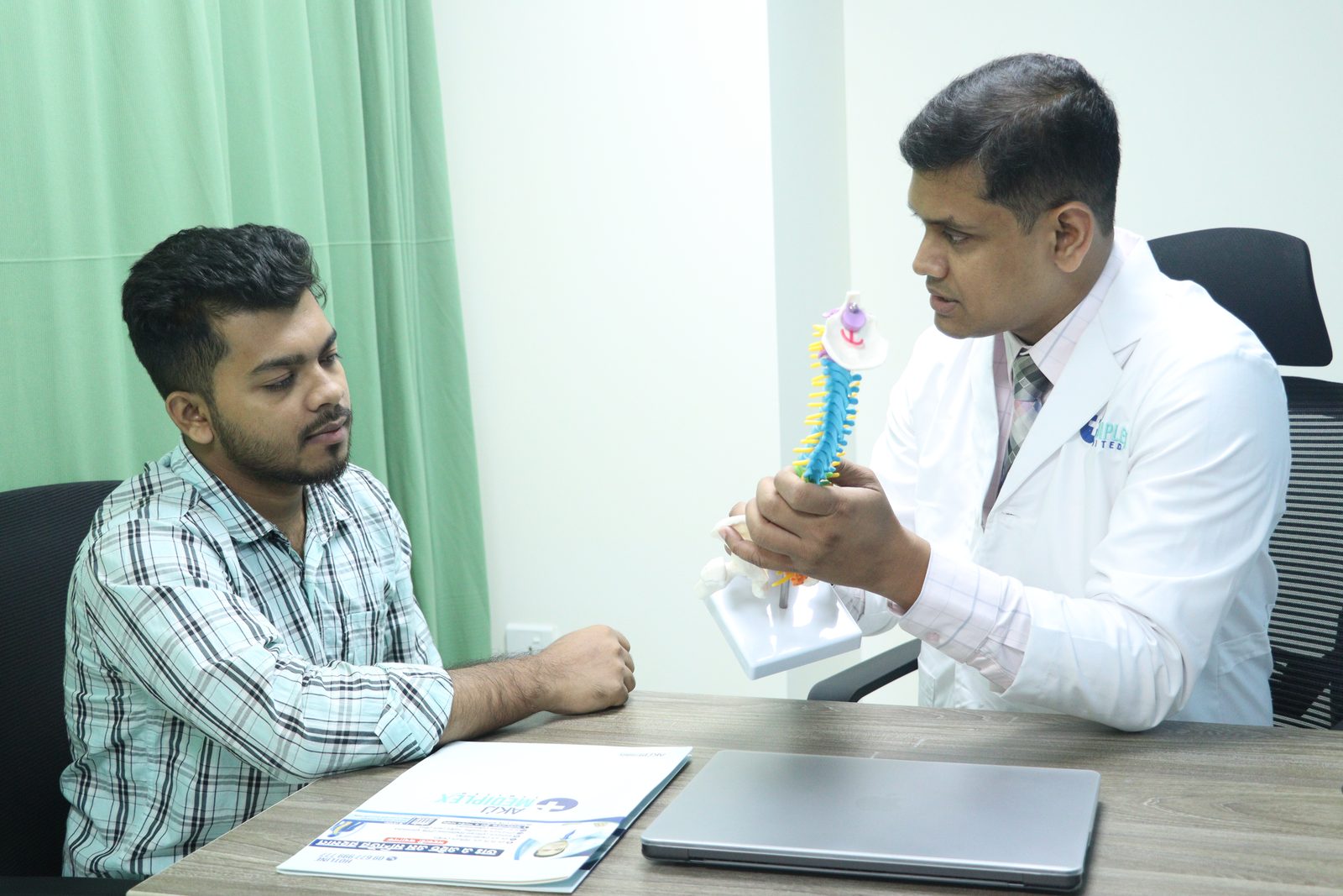 Explaining the spine — Showing a patient how a disc presses on the nerve, using a spine model